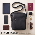 kleine schwarze Leder-Umhängetasche frontal mit Reißverschluss, daneben 8-Zoll-Tablet, Pass, Handy und Zubehör als Größenvergleich